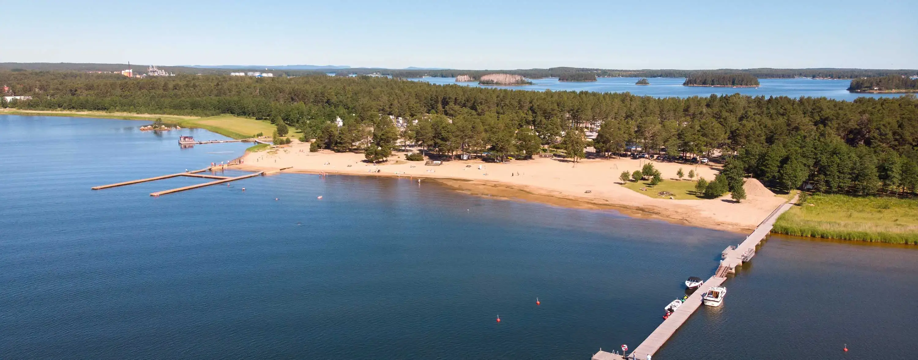 Stenö havsbad med sandstrand och klart vatten vid Söderhamns kust